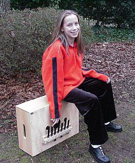 Photo of girl sitting on a bassbox and playing it